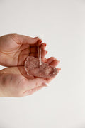 Mother holding a glass baby footprint keepsake hanging from a ribbon